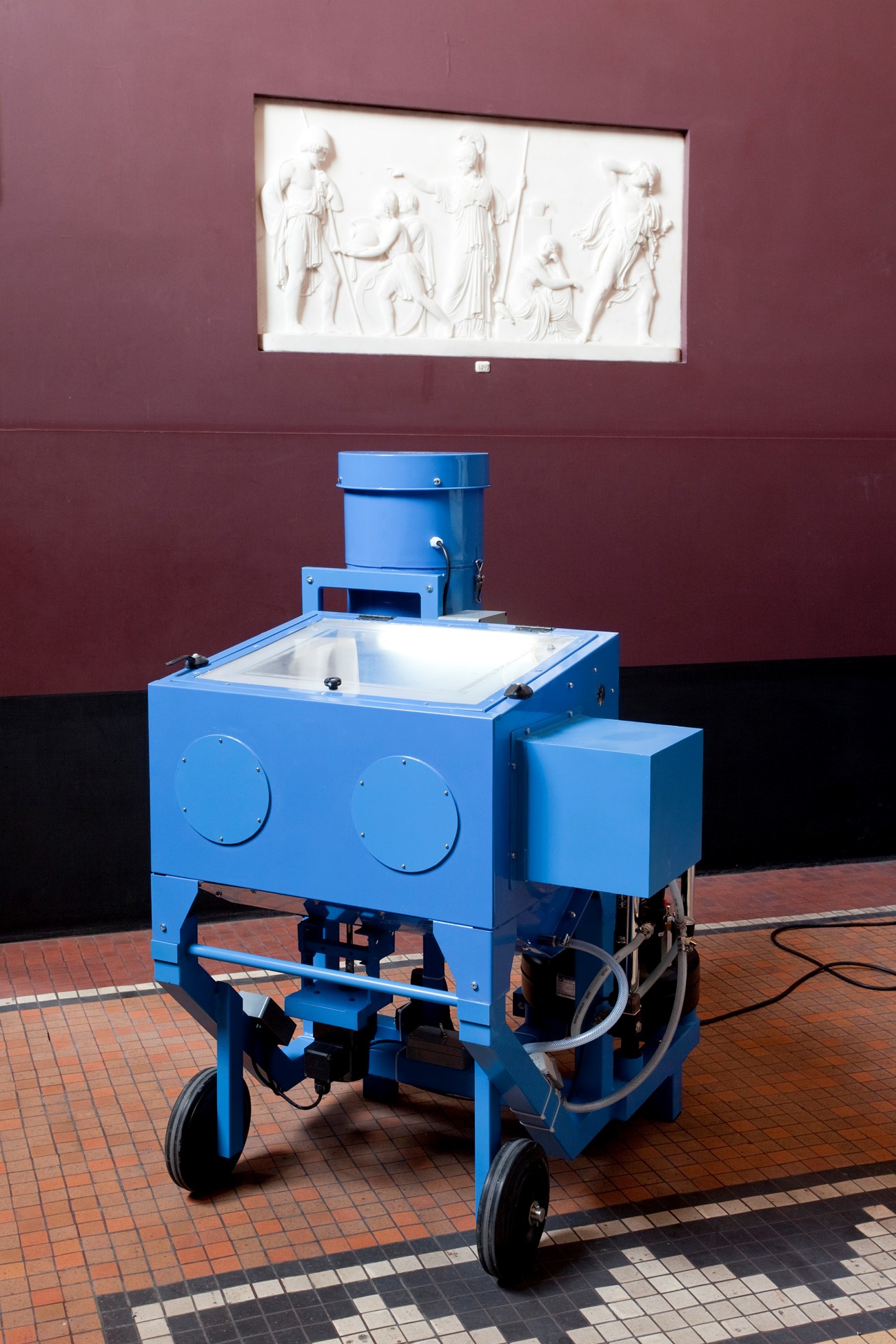 G120 (1), 2013, Iron, compressor, sand, plaster and other electronics., 110 x 100 x 80 cm. , Consisting of a rebuild sandblaster, on which a small metal arm is mounted, and directs its beam of sand and air towards a rotating platform. The figure wears out in a manner, which changes dramatically it from its starting point. Thorvaldsen.