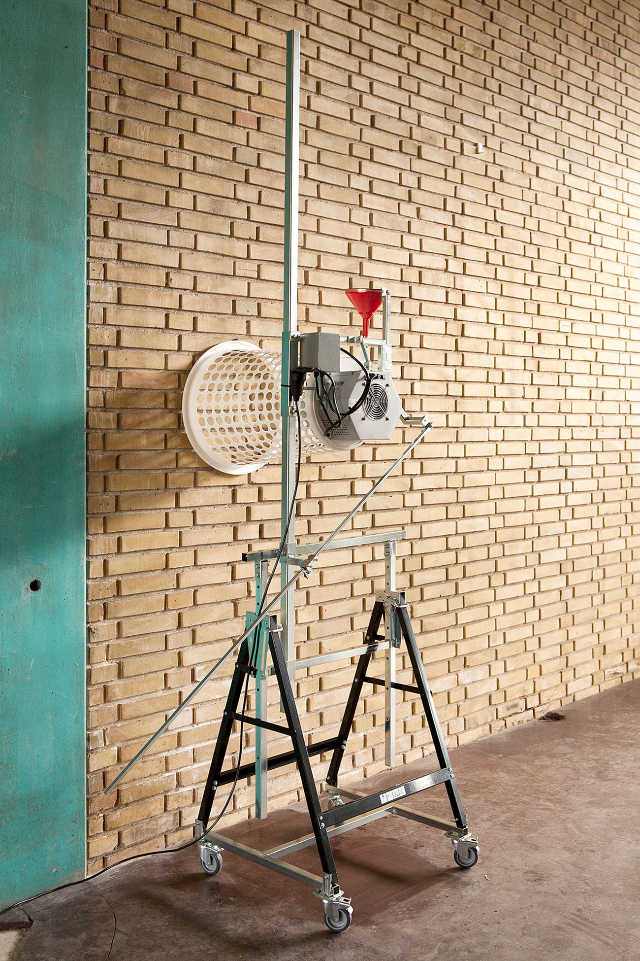 SB1, 2017, Soap, iron, plastic laundry basket and electronics, 220 x 60 x 80 cm, The machine blows soap bubbles on to the wall. The bubbles burst when they hit the wall and leaves a mark of soap. When soap is blown onto the same spot for ten days a 3 cm thick structure appears. Exhibited at the exhibition space RØM, Copenhagen 2017.